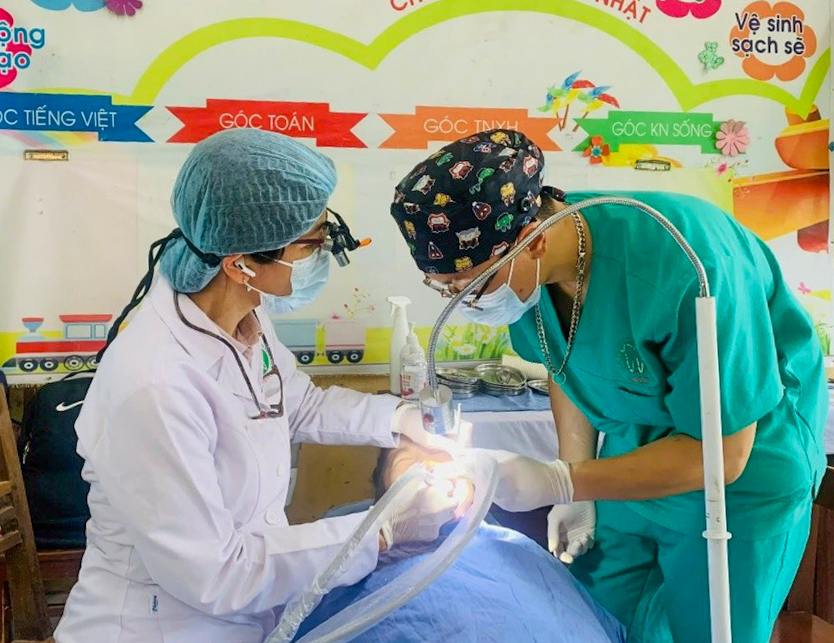 Bác sĩ Bệnh viện trám bít hố rãnh và bôi vecni Fluor cho các em học sinh